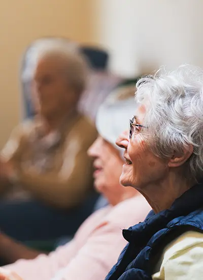 3 elderly women smiling together in a family-run care home, Ribble Valley, Lancashire