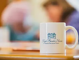 White mug with High Brake House logo on table at Ribble Valley care home