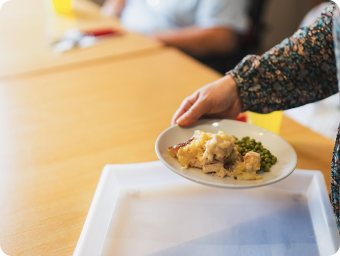 Plate of traditional meal with meat, mashed potato and peas at High Brake House care home
