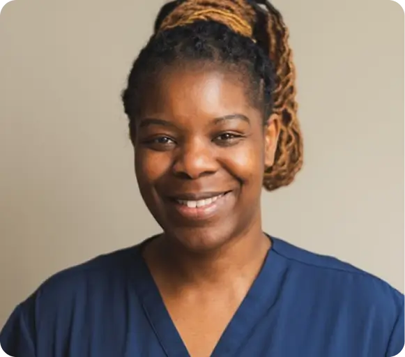 Smiling carer in navy scrubs, representing our qualified Clitheroe care team
